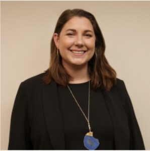 photo of Brittany Green, who is standing against a tan background and smiling